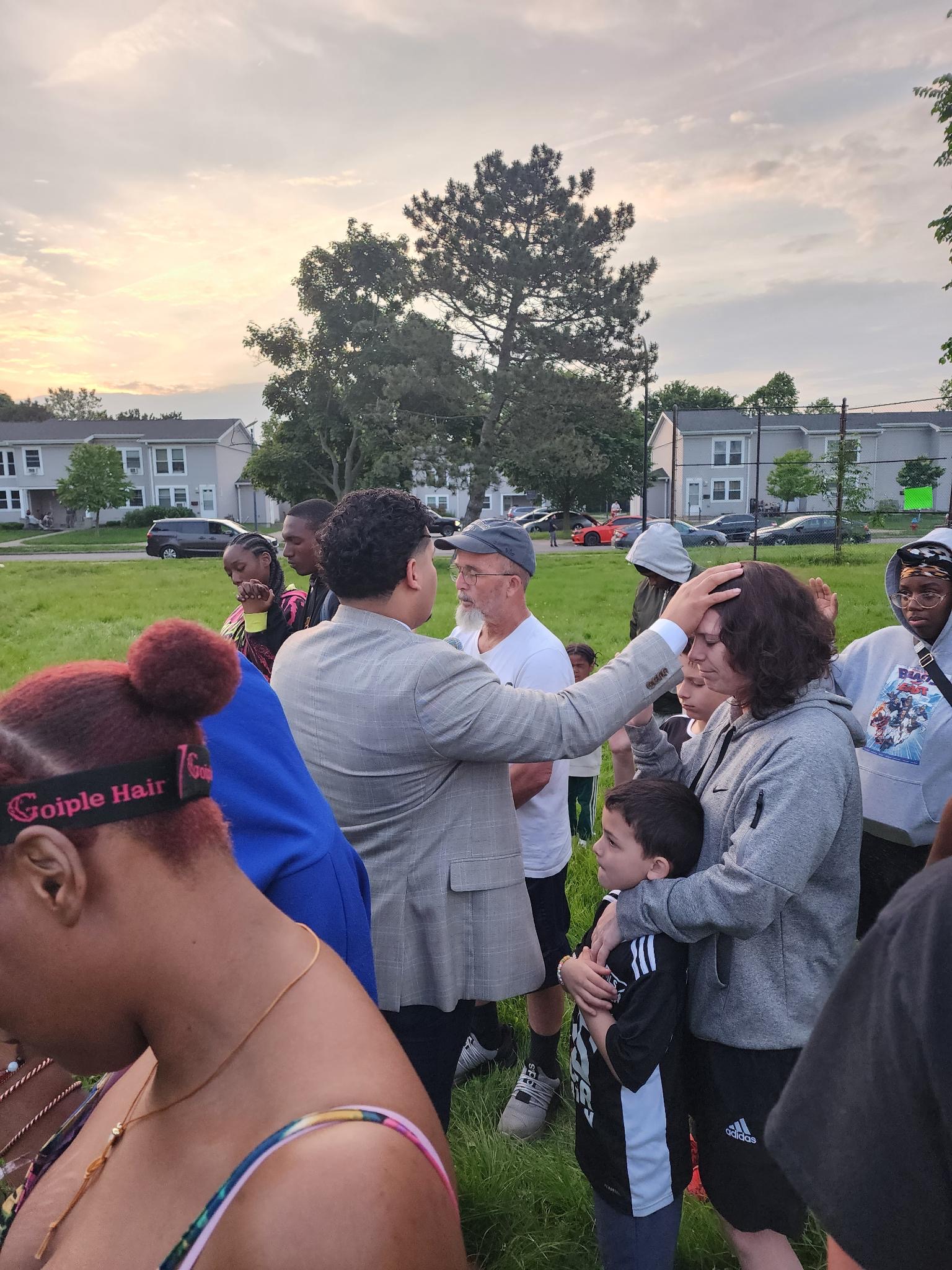 Izaiah Diaz preaching to seated children with the Buffalo skyline behind him