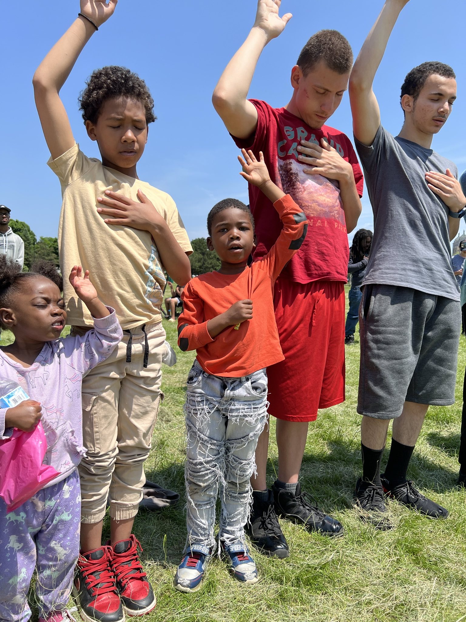 Children and youth with hands raised in worship