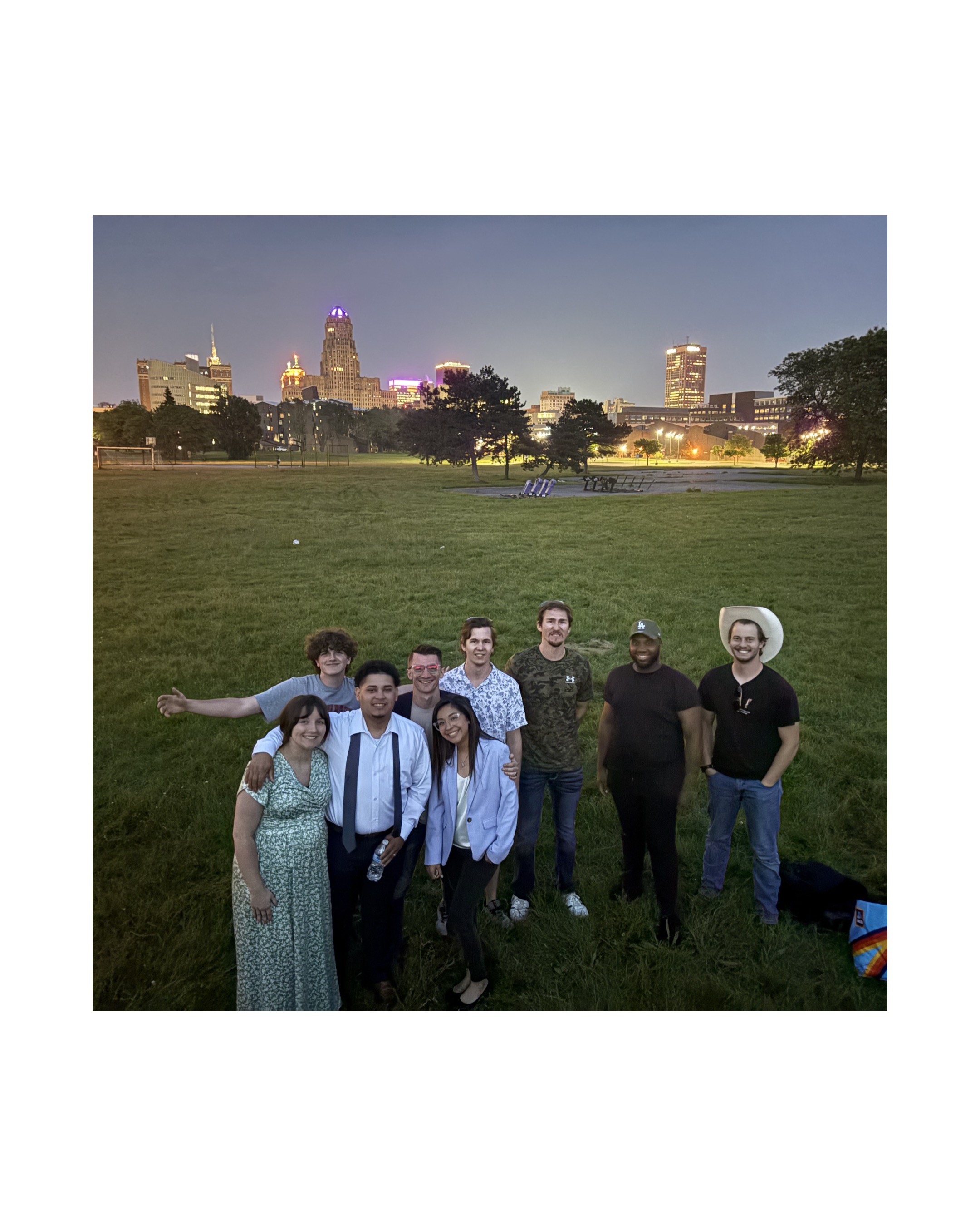 Crusade volunteer team gathered with the Buffalo skyline lit up at night behind them