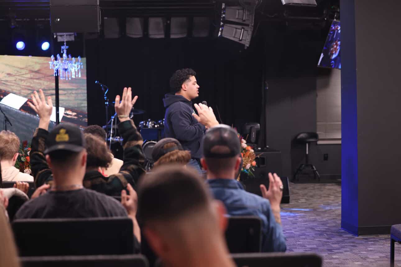 Crowd responding in worship with hands raised