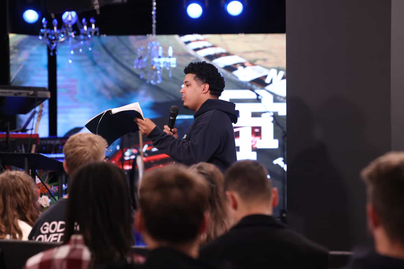 Izaiah Diaz reading from his Bible to the youth crowd