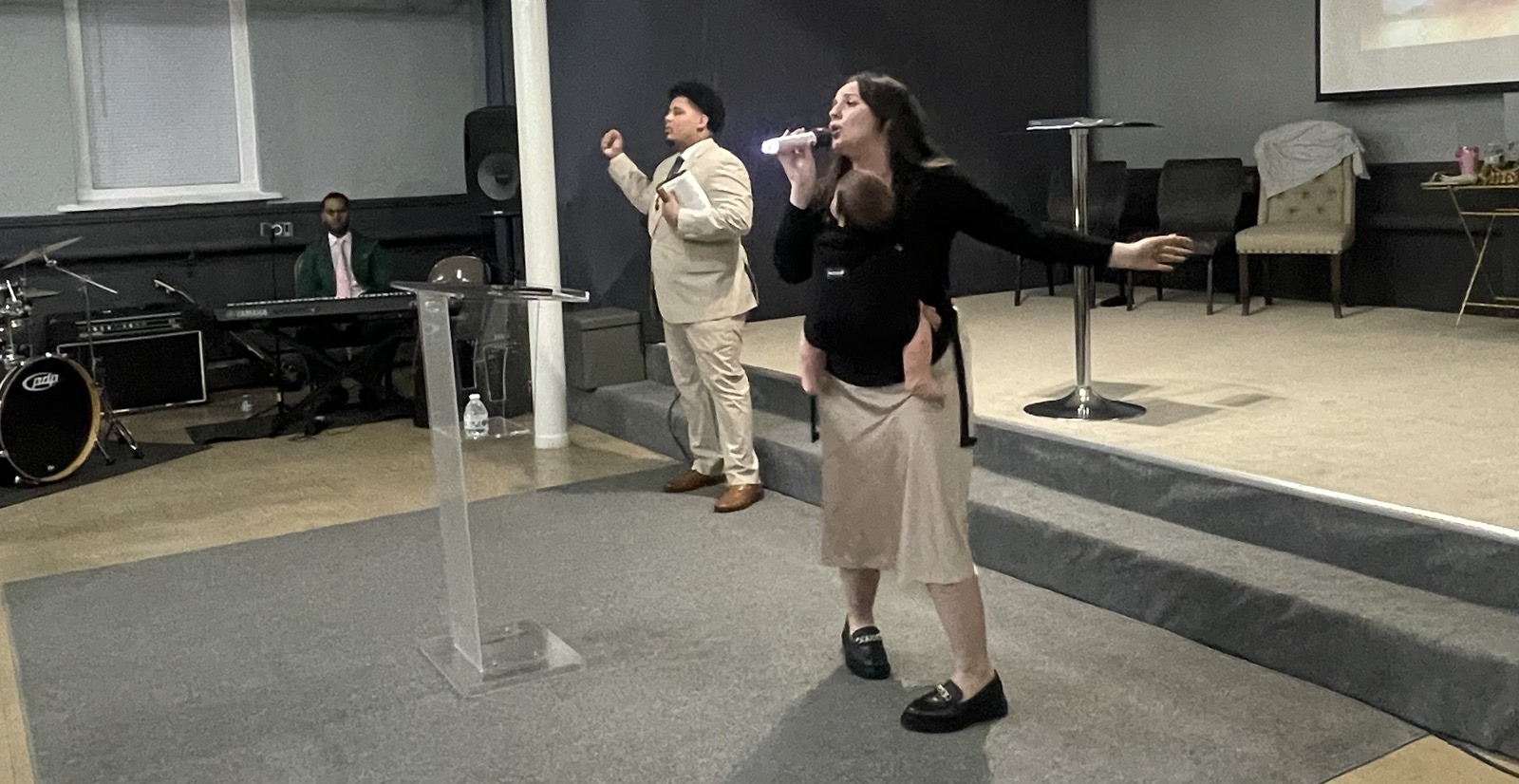 Kaylie Diaz leading worship while Izaiah preaches at the Two Day Outpouring